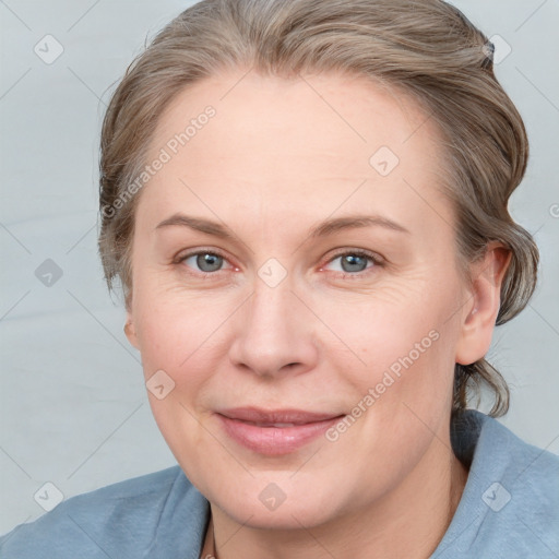 Joyful white adult female with medium  brown hair and blue eyes