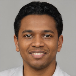 Joyful latino young-adult male with short  black hair and brown eyes