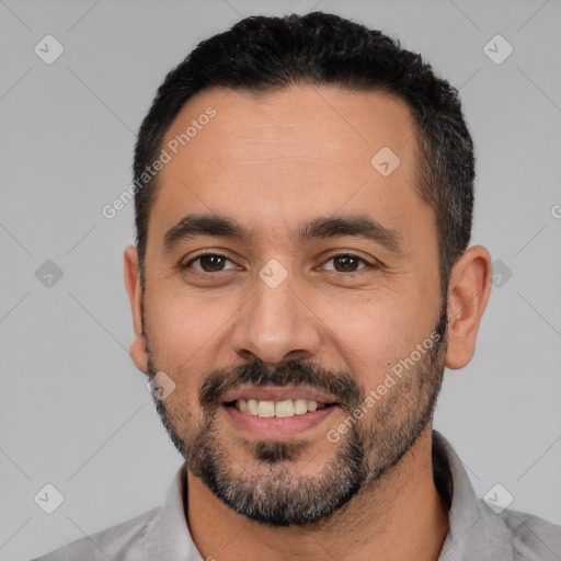 Joyful white young-adult male with short  black hair and brown eyes