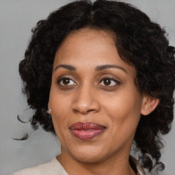 Joyful black adult female with medium  brown hair and brown eyes