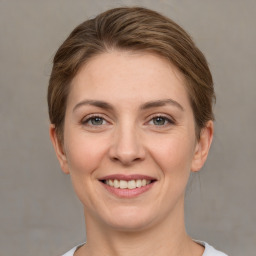 Joyful white young-adult female with short  brown hair and grey eyes