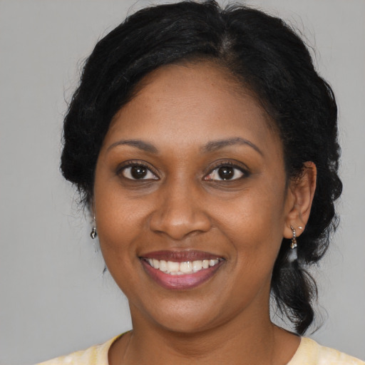 Joyful black adult female with long  brown hair and brown eyes