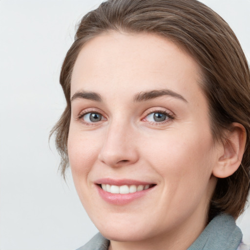 Joyful white young-adult female with medium  brown hair and blue eyes