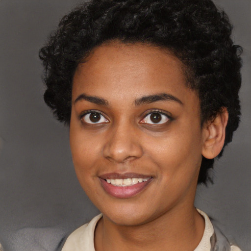 Joyful black young-adult female with short  brown hair and brown eyes