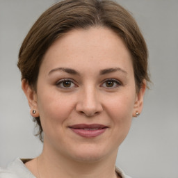 Joyful white young-adult female with short  brown hair and grey eyes