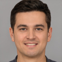 Joyful white young-adult male with short  brown hair and brown eyes