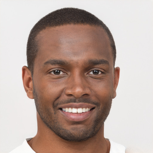 Joyful black young-adult male with short  brown hair and brown eyes