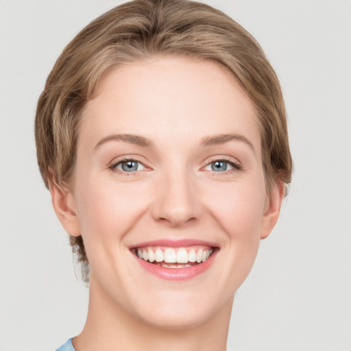 Joyful white young-adult female with medium  brown hair and green eyes