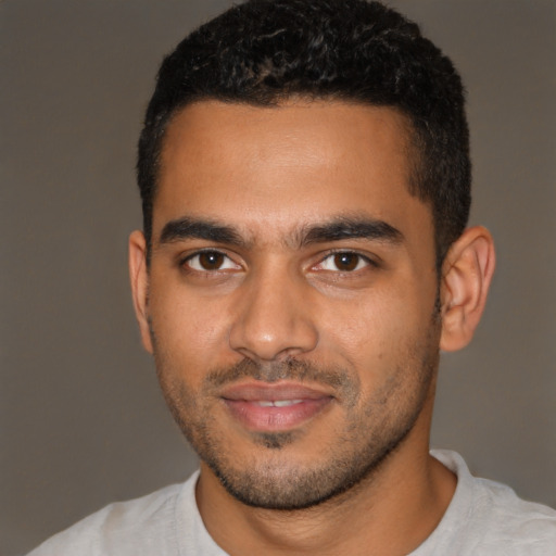 Joyful latino young-adult male with short  brown hair and brown eyes
