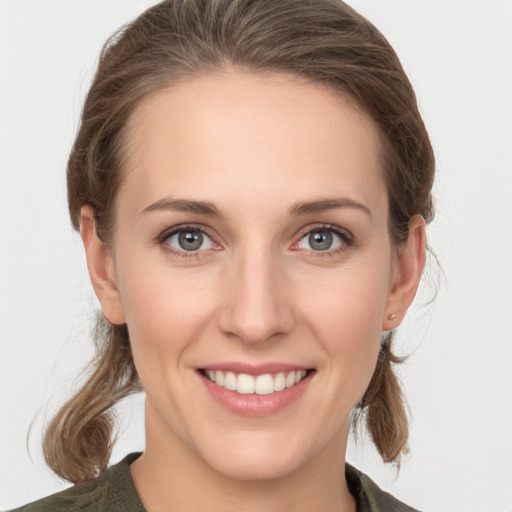 Joyful white young-adult female with medium  brown hair and grey eyes