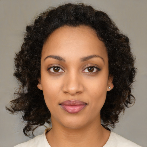 Joyful black young-adult female with medium  brown hair and brown eyes