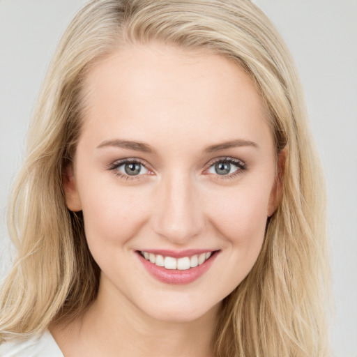 Joyful white young-adult female with long  brown hair and blue eyes