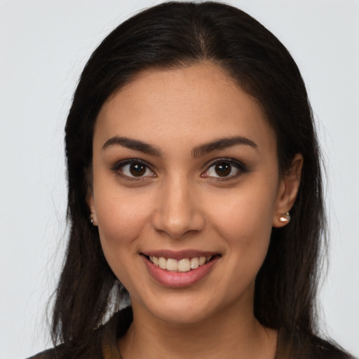 Joyful latino young-adult female with long  brown hair and brown eyes