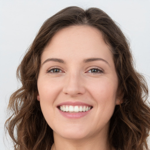 Joyful white young-adult female with long  brown hair and green eyes