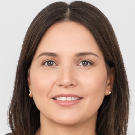 Joyful white young-adult female with long  brown hair and brown eyes