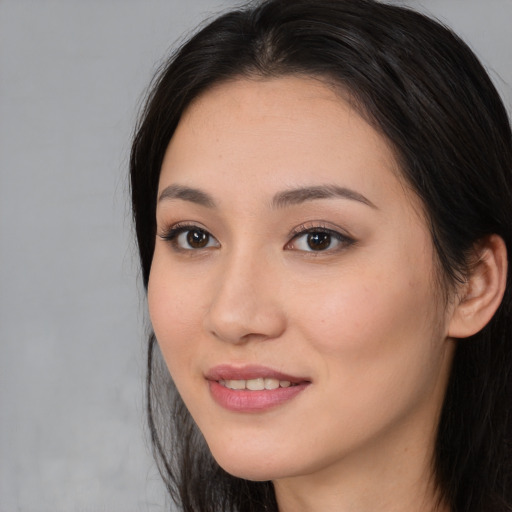 Joyful asian young-adult female with long  brown hair and brown eyes