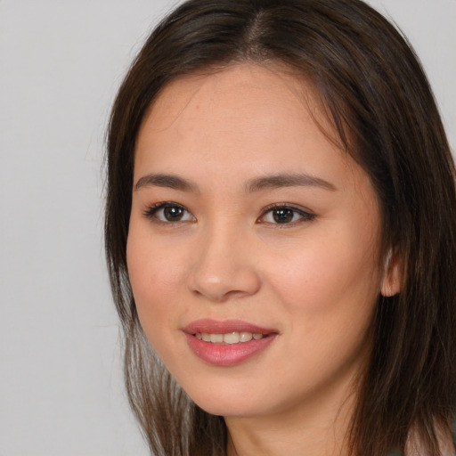 Joyful white young-adult female with long  brown hair and brown eyes