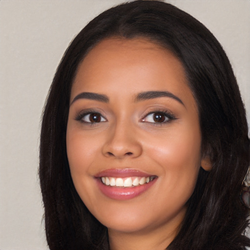 Joyful latino young-adult female with long  black hair and brown eyes