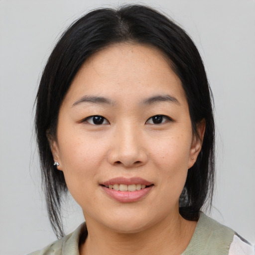 Joyful asian young-adult female with medium  brown hair and brown eyes