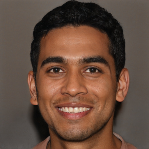Joyful latino young-adult male with short  black hair and brown eyes