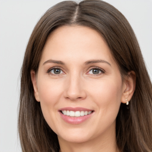 Joyful white young-adult female with long  brown hair and brown eyes