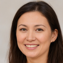 Joyful white young-adult female with long  brown hair and brown eyes