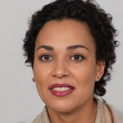 Joyful black adult female with long  brown hair and brown eyes