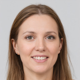 Joyful white young-adult female with long  brown hair and grey eyes