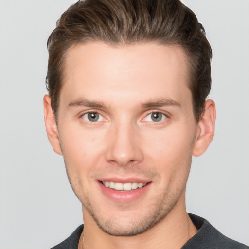 Joyful white young-adult male with short  brown hair and grey eyes