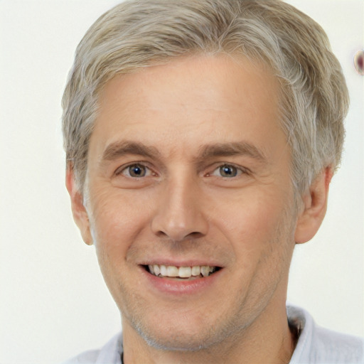 Joyful white adult male with short  blond hair and brown eyes