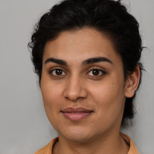 Joyful latino young-adult female with short  brown hair and brown eyes