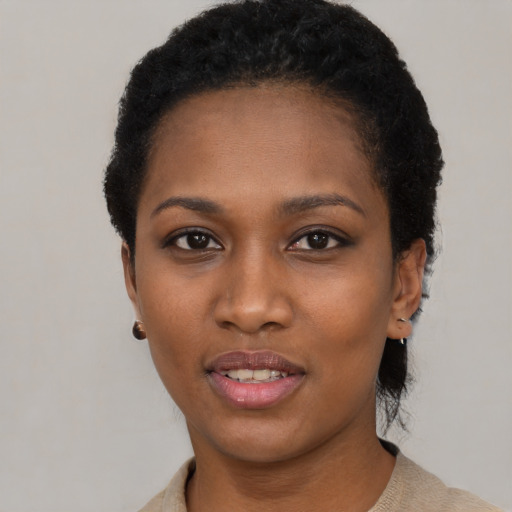 Joyful black young-adult female with short  black hair and brown eyes