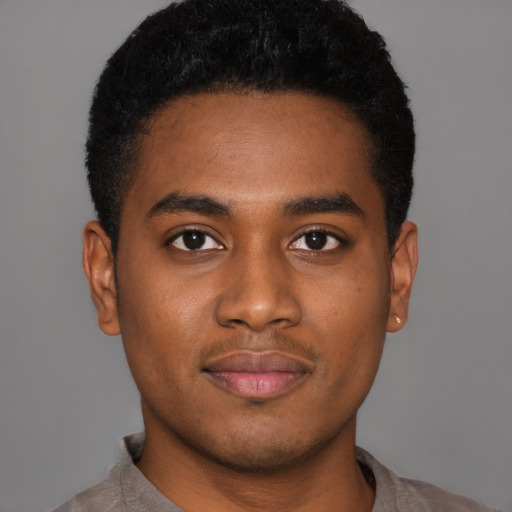 Joyful black young-adult male with short  black hair and brown eyes