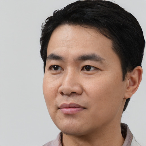 Joyful asian young-adult male with short  black hair and brown eyes