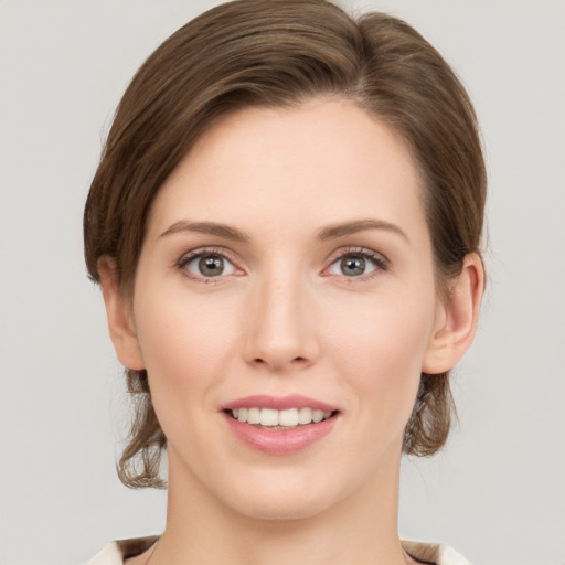 Joyful white young-adult female with medium  brown hair and grey eyes