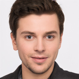 Joyful white young-adult male with short  brown hair and grey eyes