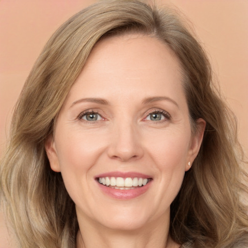 Joyful white adult female with long  brown hair and blue eyes