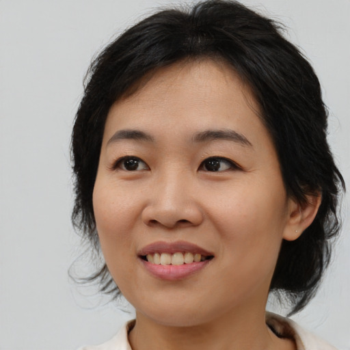 Joyful asian young-adult female with medium  brown hair and brown eyes