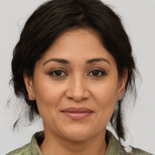 Joyful latino adult female with medium  brown hair and brown eyes