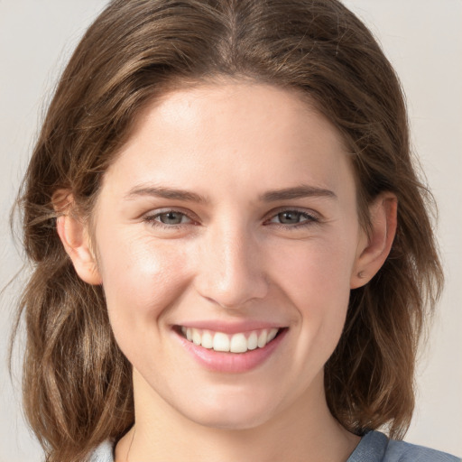 Joyful white young-adult female with medium  brown hair and grey eyes