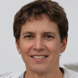 Joyful white adult male with short  brown hair and brown eyes