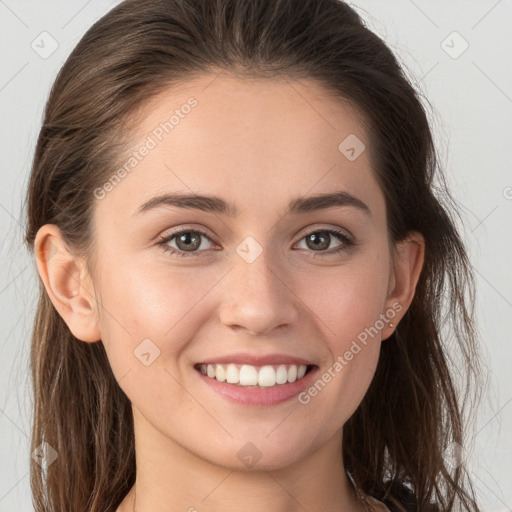 Joyful white young-adult female with long  brown hair and brown eyes