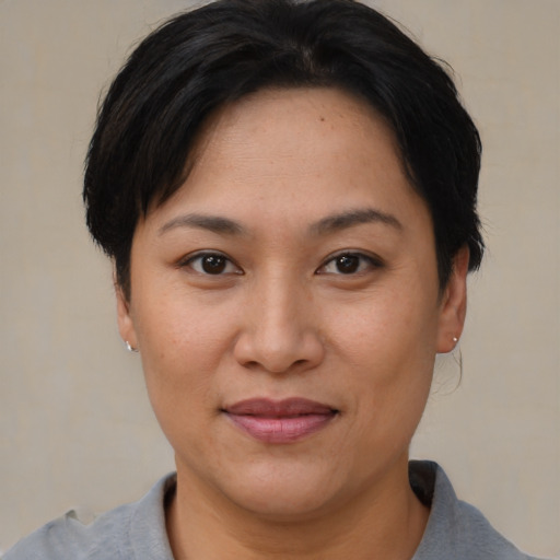 Joyful asian young-adult female with short  brown hair and brown eyes