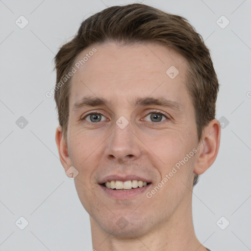 Joyful white young-adult male with short  brown hair and grey eyes