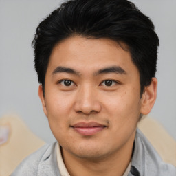 Joyful asian young-adult male with short  black hair and brown eyes