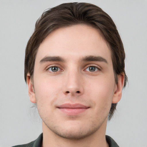 Joyful white young-adult male with short  brown hair and grey eyes