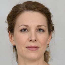 Joyful white adult female with medium  brown hair and grey eyes