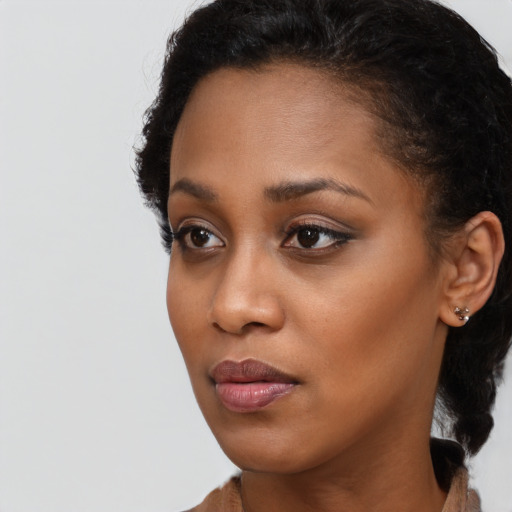 Joyful black young-adult female with short  brown hair and brown eyes