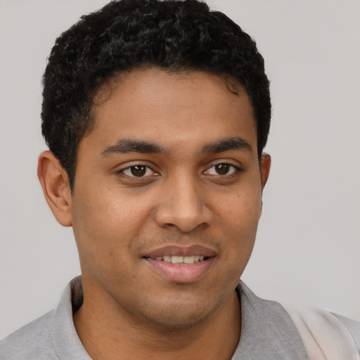 Joyful latino young-adult male with short  brown hair and brown eyes
