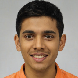 Joyful latino young-adult male with short  black hair and brown eyes